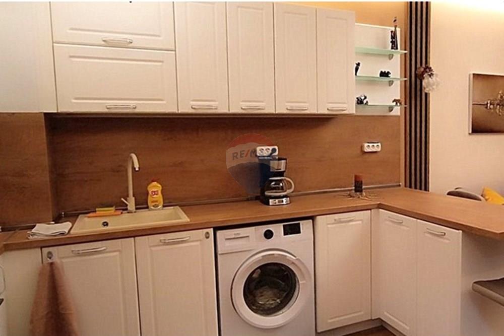 Апартамент - Под наем - гр. Варна, Област Варна, България - viber_image_2024-10-14_13-16-46-293.jpg - Кухня към всекидневната - 360391034-52